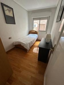 a small bedroom with a bed and a window at Apartamento Cerca Estacion de Bus in Murcia