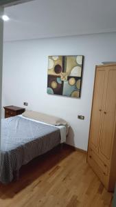 a bedroom with a bed and a painting on the wall at Apartamento Cerca Estacion de Bus in Murcia