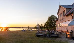 a group of people sitting on benches outside of a building at Bungenäs Badhotell in Fårösund +24 photos