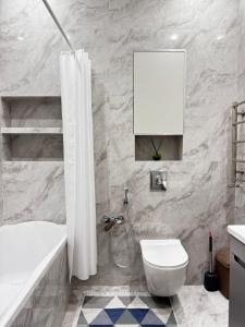 a bathroom with a white tub and a toilet and a sink at Посуточно 3 комн в ЖК Аль Фараби in Shymkent +2 photos