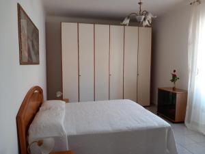 a bedroom with a bed and a large white cabinet at Villa Wanda in Anzio