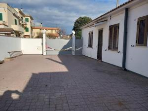 un edificio blanco con una puerta y una valla en Villa Wanda, en Anzio