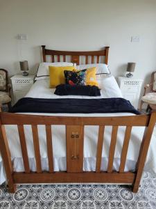 un letto con cuscini gialli e neri sopra di The Tin Shed a Tara