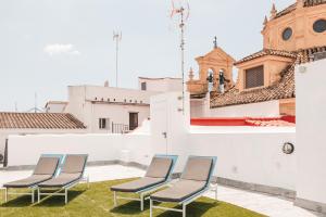 szereg krzeseł na dachu budynku w obiekcie ASTUTO 21 Suites - Adults Only w mieście Jerez de la Frontera