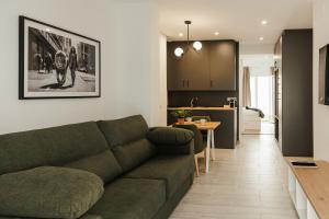 salon z zieloną kanapą i kuchnią w obiekcie ASTUTO 21 Suites - Adults Only w mieście Jerez de la Frontera