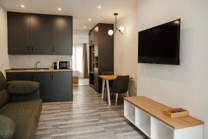 kuchnia i salon z kanapą i stołem w obiekcie ASTUTO 21 Suites - Adults Only w mieście Jerez de la Frontera