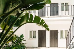 biały budynek z brązowymi drzwiami i roślinami w obiekcie ASTUTO 21 Suites - Adults Only w mieście Jerez de la Frontera