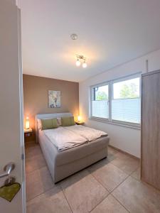 a bedroom with a bed and a large window at wolke 7, Bergblick Apartment, Kingsizebett & Schlafcouch, Balkon & Garten in Kiefersfelden