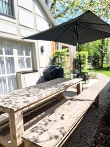 a wooden picnic table with an umbrella in front of a house at TauberChalet I Privates Boutique-Ferienhaus mit Whirlpool, Sauna, Garten, Naturmagie & ZellBoost in Rothenburg ob der Tauber +98 photos
