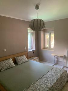 a bedroom with a large bed and a chandelier at Eva House in Kanallaki