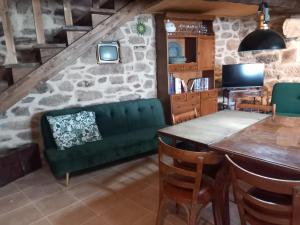 a living room with a green couch and a table at A casa da Touza in Pensos