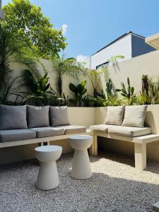 a patio with a couch and tables and plants at Cozy Living Kalos Villa in Kerobokan