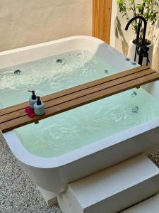 a bath tub with a wooden deck on top of it at Cozy Living Kalos Villa in Kerobokan +23 photos