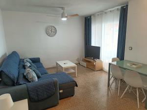 a living room with a blue couch and a table at PLAYA PONIENTE, COBLANCA XVI (A 200m DE LA PLAYA) in Benidorm