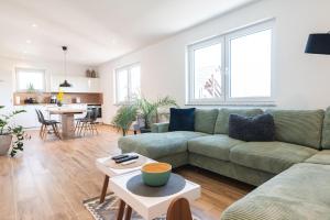 a living room with a couch and a table at Lilias Ferienwohnung in Losheim