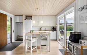 a kitchen with white cabinets and a wooden ceiling at Holiday Home Egernsund With A Fireplace 316 in Egernsund