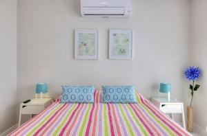 a bedroom with a bed with a colorful striped bedspread at Ocean View! 2-Bedroom Cosy Condo in Portimão