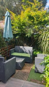 patio con panchina e ombrellone di Gignac 34 Maison avec jardin 3 min du centre ville a Gignac