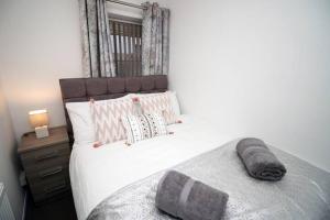 a bedroom with a large white bed with pillows at City Centre, Parking, Smart Tv's in all rooms in Swansea