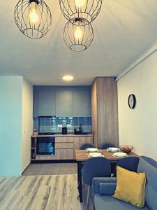 a living room with a table and blue chairs at Skyline Forest View Timisoara in Timişoara
