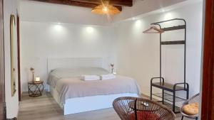 a white bedroom with a bed and two chairs at Menta Cinque Terre in Vernazza