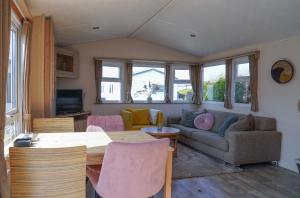 a living room with a table and a couch at Camping de Zandput - ZP 237 in Vrouwenpolder