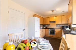 a kitchen with a table with fruit on it at 3 Bedroom House By B and R Serviced Accommodation Amesbury With Wifi & Free Parking in Amesbury +11 photos
