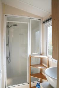 a bathroom with a shower and a white sink at Camping de Zandput - ZP 237 in Vrouwenpolder