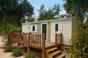 een tiny house met een veranda en een terras bij Chalet 3 étoiles - Piscine - ccaibfi in Saint-Jean-du-Gard