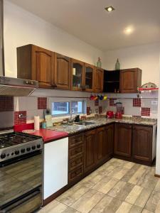 una cucina con armadi in legno e piano di lavoro rosso di Ático Mediterráneo a San Francisco Altre 6 foto