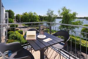 einen Tisch mit Stühlen und ein Buch auf dem Balkon in der Unterkunft Seehof Seehof 121 in Bansin