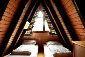 two beds in a wooden cabin with a window at Ferienhaus In Waldkirchen Mit Garten Und Seeblick in Waldkirchen