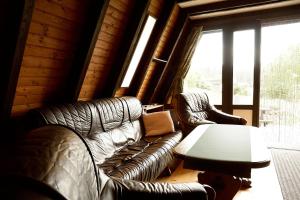 a living room with leather couches and a table at Ferienhaus In Waldkirchen Mit Garten Und Seeblick in Waldkirchen