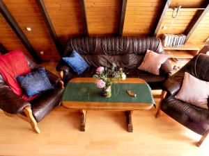 a living room with two leather couches and a table at Ferienhaus In Waldkirchen Mit Garten Und Seeblick in Waldkirchen