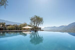 a large pool of blue water with mountains in the background at Villa Erika in Tirolo