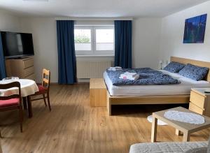 a bedroom with a bed and a table and a window at Modern Gemütlich in Pflach