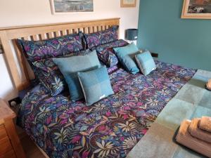 a bed with blue pillows on it in a bedroom at The Weavers Cottage in Leurbost