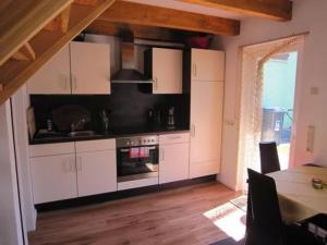 une cuisine avec des armoires blanches et une cuisinière dans l'établissement Ferienhaus Malchow Mit Grill, Garten Und Terrasse, à Malchow 9 autres photos
