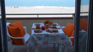 a table with food and a view of the beach at Terrazza Sul Mare in Terme Vigliatore