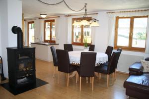 Un comedor con mesa y sillas y una estufa. en Ruhige Wohnung Im Ortszentrum, en Sankt Gallenkirch