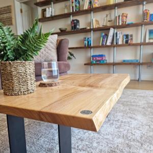 a wooden table with a glass and a plant on it at Seaview Sands Beach Apartment in Southbourne