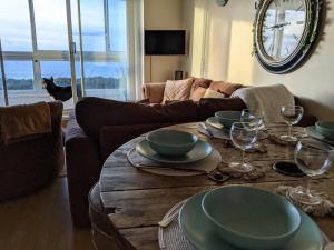 a living room with a table with plates and wine glasses at Seaview Sands Beach Apartment in Southbourne