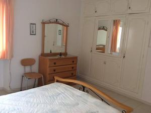 1 dormitorio con cama, tocador y espejo en Villa Kenza, en Nabeul