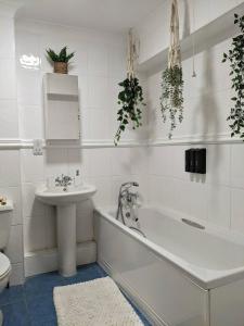 a bathroom with a tub and a sink and a toilet at Seaview Sands Beach Apartment in Southbourne +20 photos