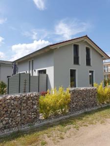 una casa bianca con un muro di pietra di Ferienhaus Vanessa Für 8 Personen a Dümmer
