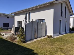 una casa bianca con una recinzione nel cortile di Ferienhaus Vanessa Für 8 Personen a Dümmer