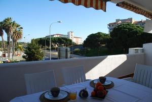 un tavolo con piatti di frutta in cima a un balcone di Apartamentos Aguadulce El Portil a El Portil