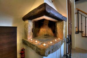 a large stone fireplace with lights on it at Stone House Kotli in Kotli