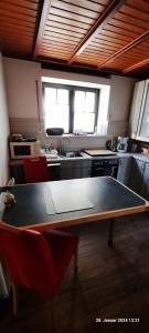a kitchen with a table and red chairs in it at Festung Zu Ketghe in Kettig