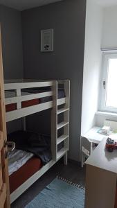 a bedroom with two bunk beds and a desk at Butje in Zinnowitz +9 photos